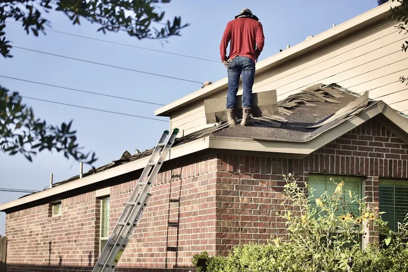 Professional roofer working on a residential roof in Saconesset Hills